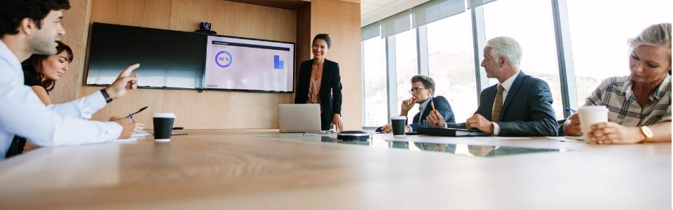 office board room meeting with presentation on wall-mounted television